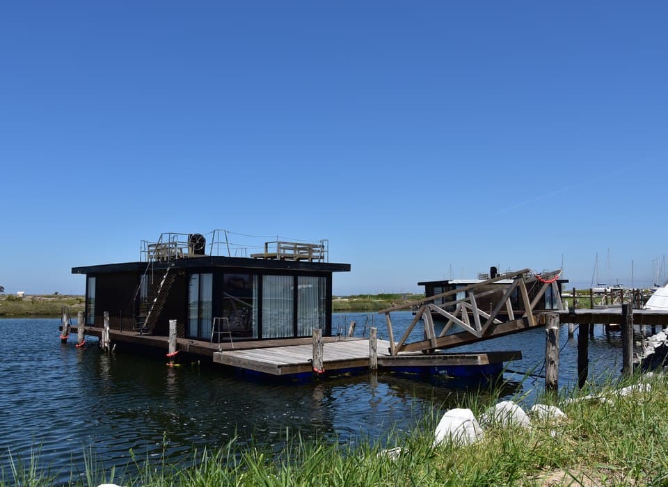 Casa-barco ao pôr do sol com reflexos na água